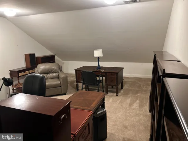 a spacious bedroom with a bed and a lamp