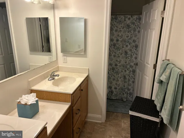 a bedroom with a bed lamps and a large mirror on the dresser