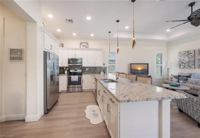 a kitchen with stainless steel appliances granite countertop a sink refrigerator and cabinets