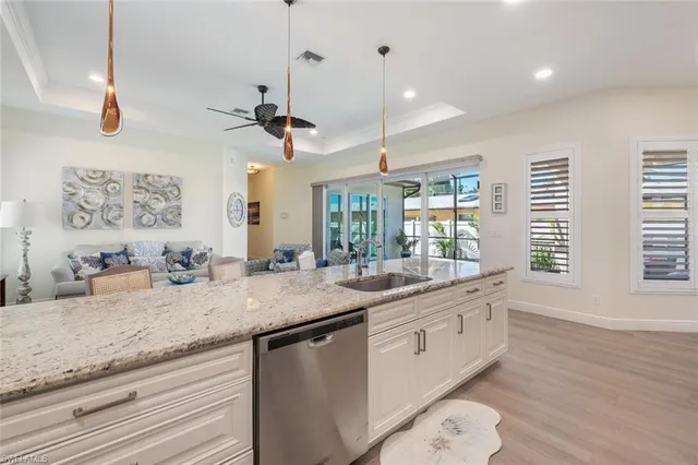 a kitchen with granite countertop a sink and a wooden floor