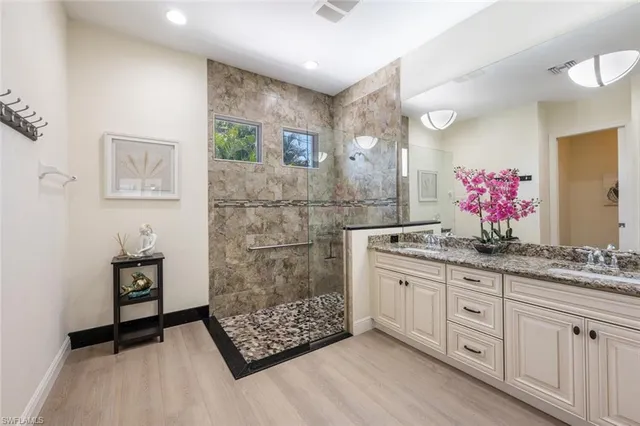 a bathroom with a double vanity sink mirror and shower