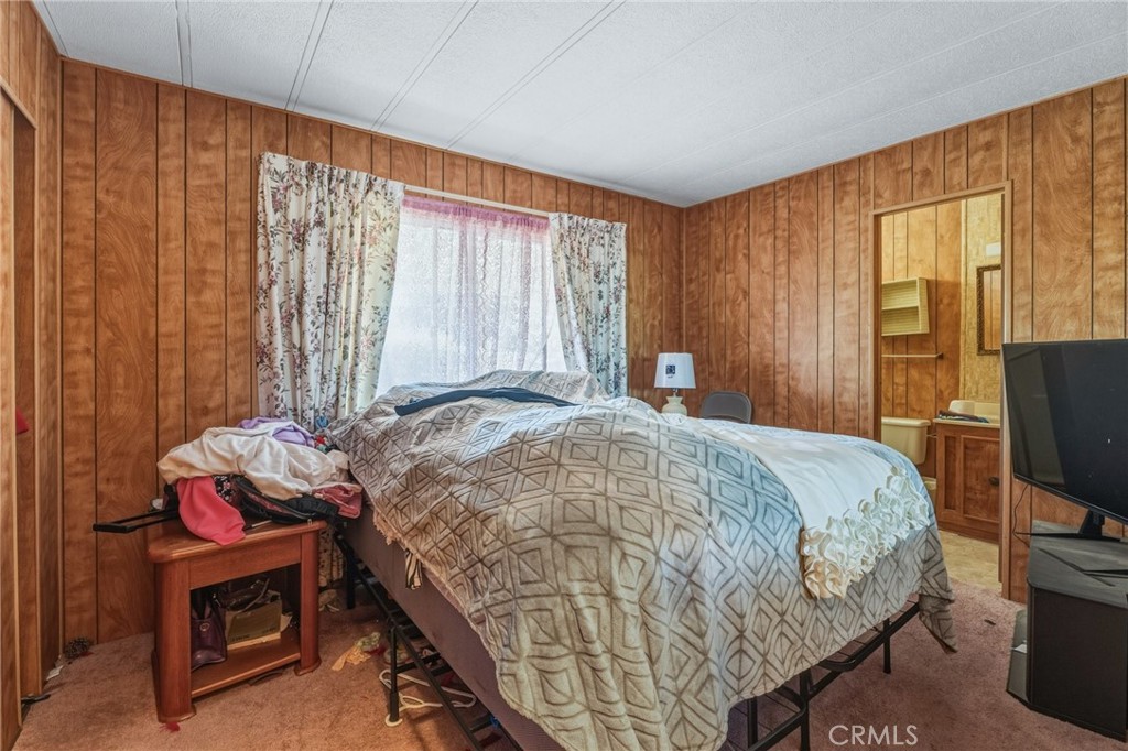 20683 Waalew Road, Unit B201 Apple Valley, CA 92307 - Photo 18 of 32 a bedroom with a bed and a tv on the dresser