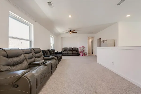 a living room with furniture a ceiling fan and a window
