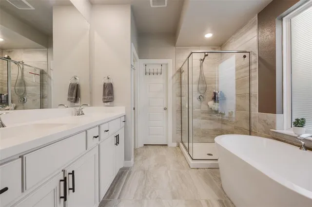 a spacious bathroom with a double vanity sink toilet mirror and bathtub