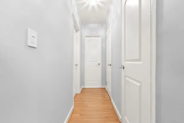 a view of a hallway with wooden floor