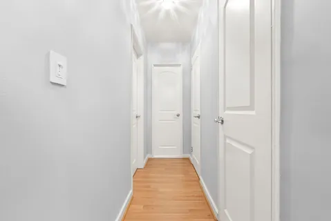a view of a hallway with wooden floor