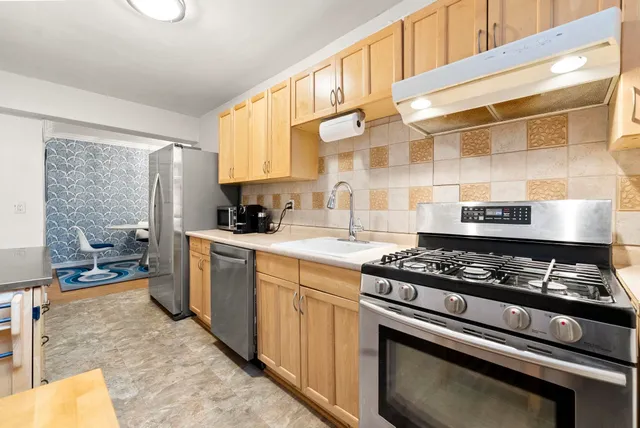 a kitchen with a stove a sink and a cabinets