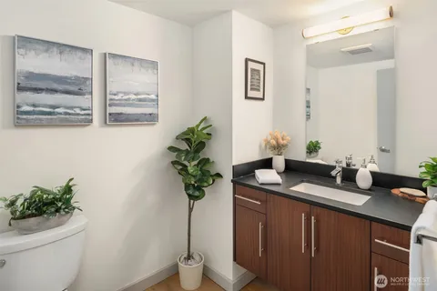 a bathroom with a granite countertop sink a toilet and a mirror