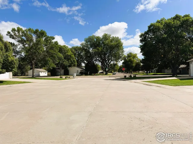 a view of swimming pool with outdoor seating and trees in the background