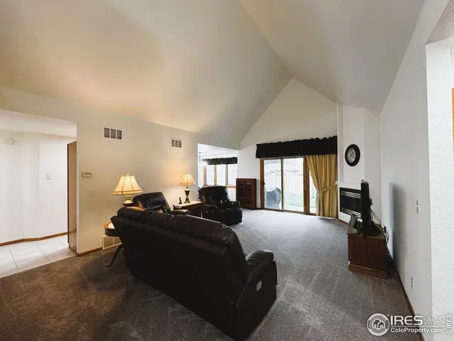 a living room with furniture a large window and dresser
