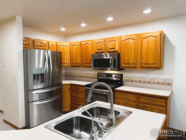 a kitchen with stainless steel appliances a stove a sink and a refrigerator