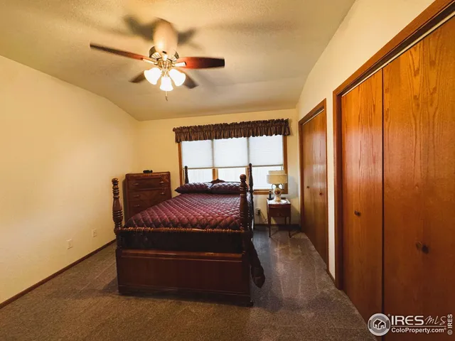a spacious bedroom with a bed and a chandelier