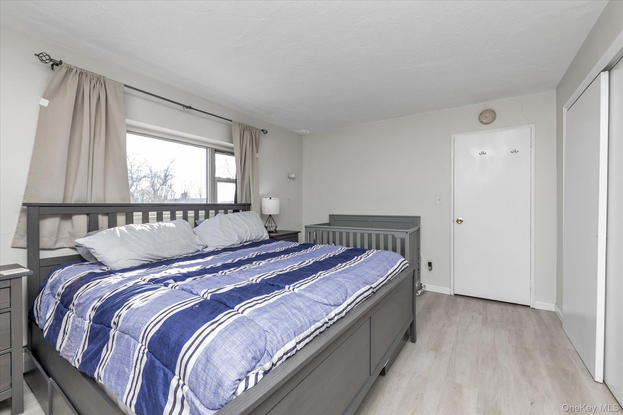 222 Smith Street, Unit 4F Freeport, NY 11520 - Photo 12 of 16 a bed sitting in a bedroom next to a window