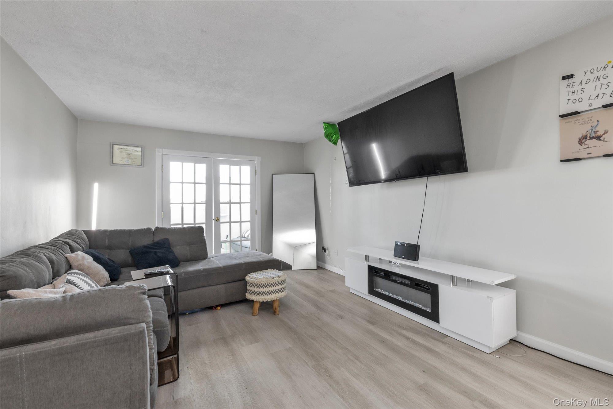 222 Smith Street, Unit 4F Freeport, NY 11520 - Photo 4 of 16 a living room with furniture and a flat screen tv