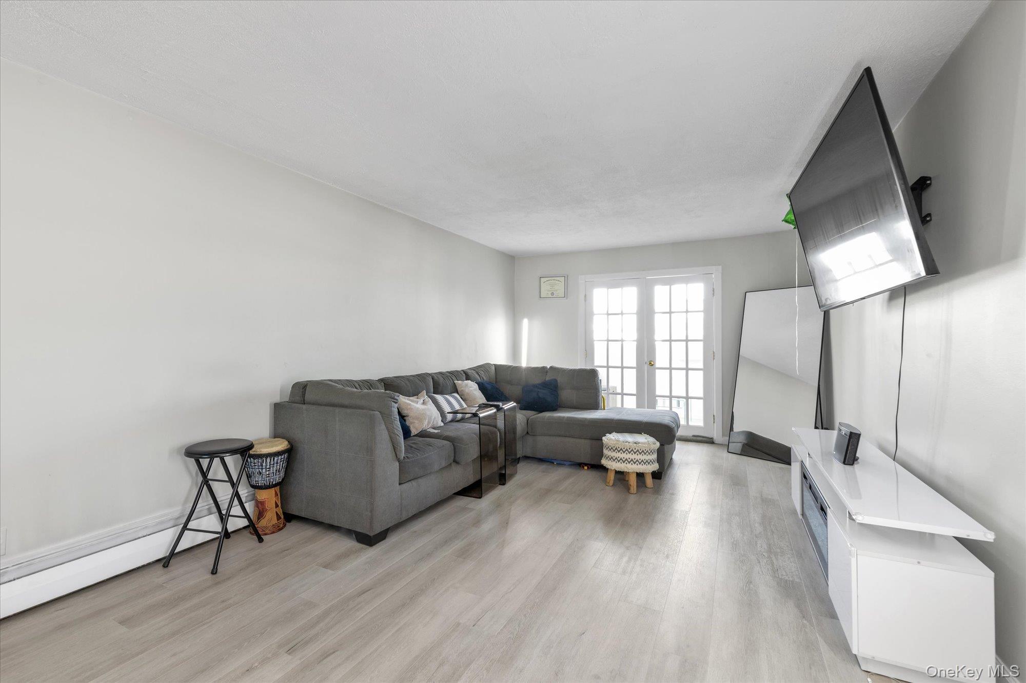 222 Smith Street, Unit 4F Freeport, NY 11520 - Photo 5 of 16 a living room with furniture and a wooden floor