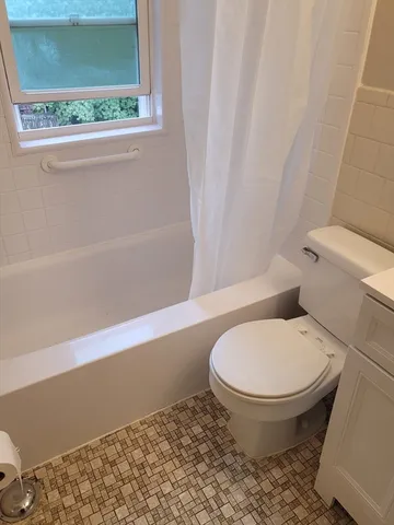a bathroom with a toilet and a shower