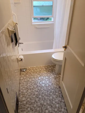 a bathroom with a toilet and a shower