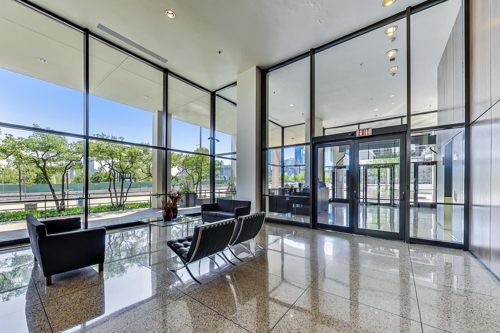 360 East Randolph Street, Unit 1007 Chicago, IL 60601 - Photo 4 of 28 a living room with furniture and large windows