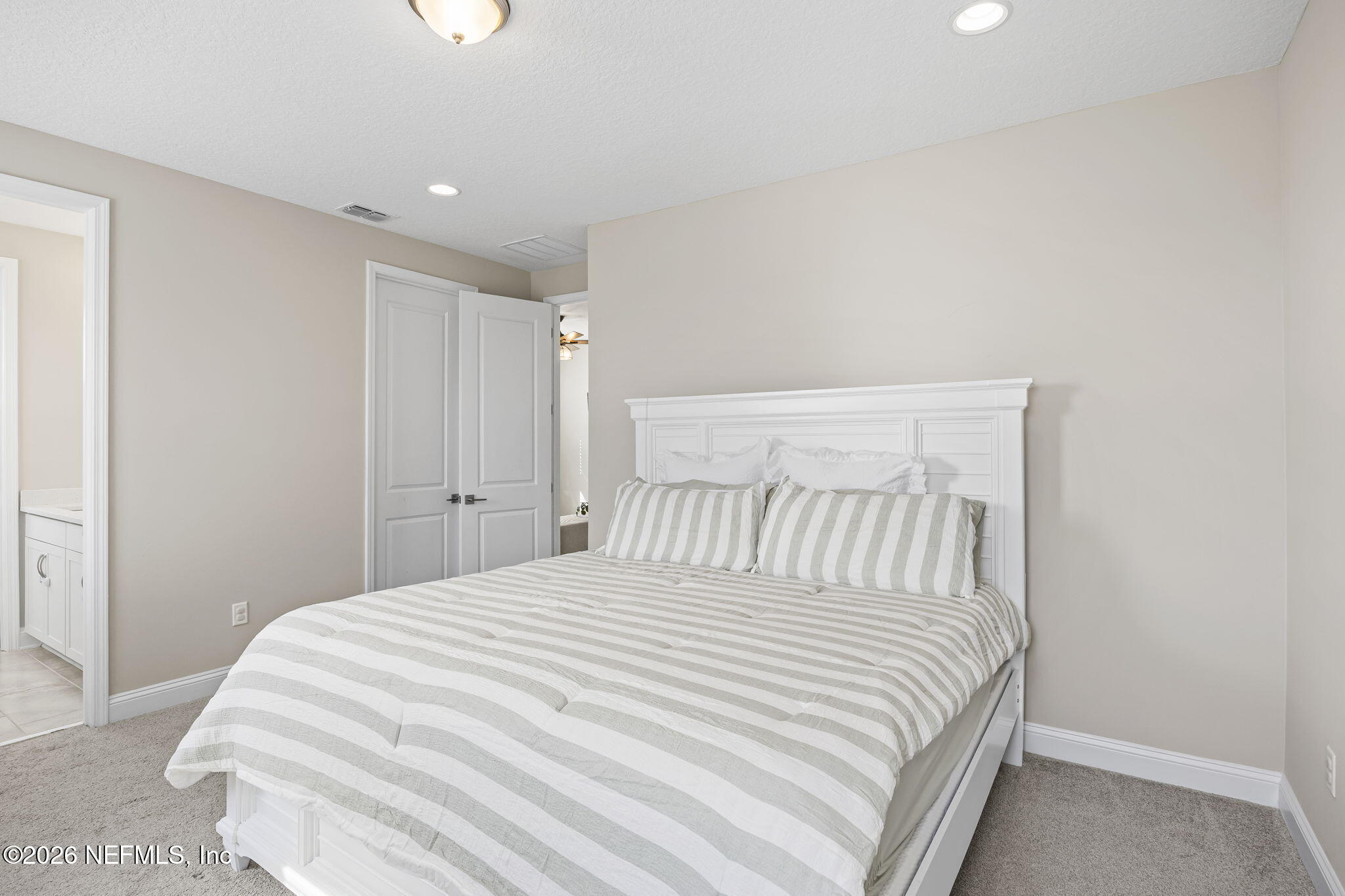 385 Rum Runner Way St. Johns, FL 32259 - Photo 19 of 35 a bedroom with a large bed and a chandelier