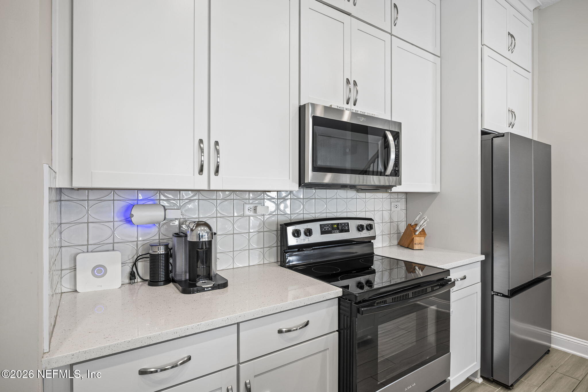 385 Rum Runner Way St. Johns, FL 32259 - Photo 6 of 35 a kitchen with granite countertop white cabinets and stainless steel appliances