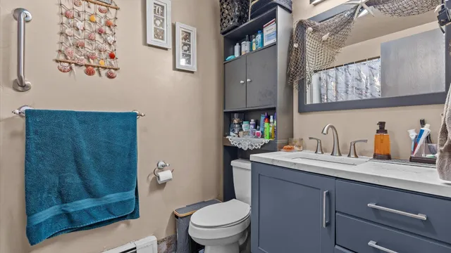 a bathroom with a granite countertop toilet sink and a mirror