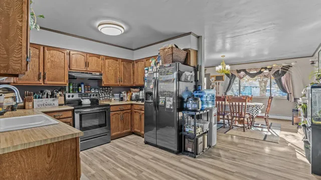 a kitchen with stainless steel appliances granite countertop a refrigerator and a stove top oven
