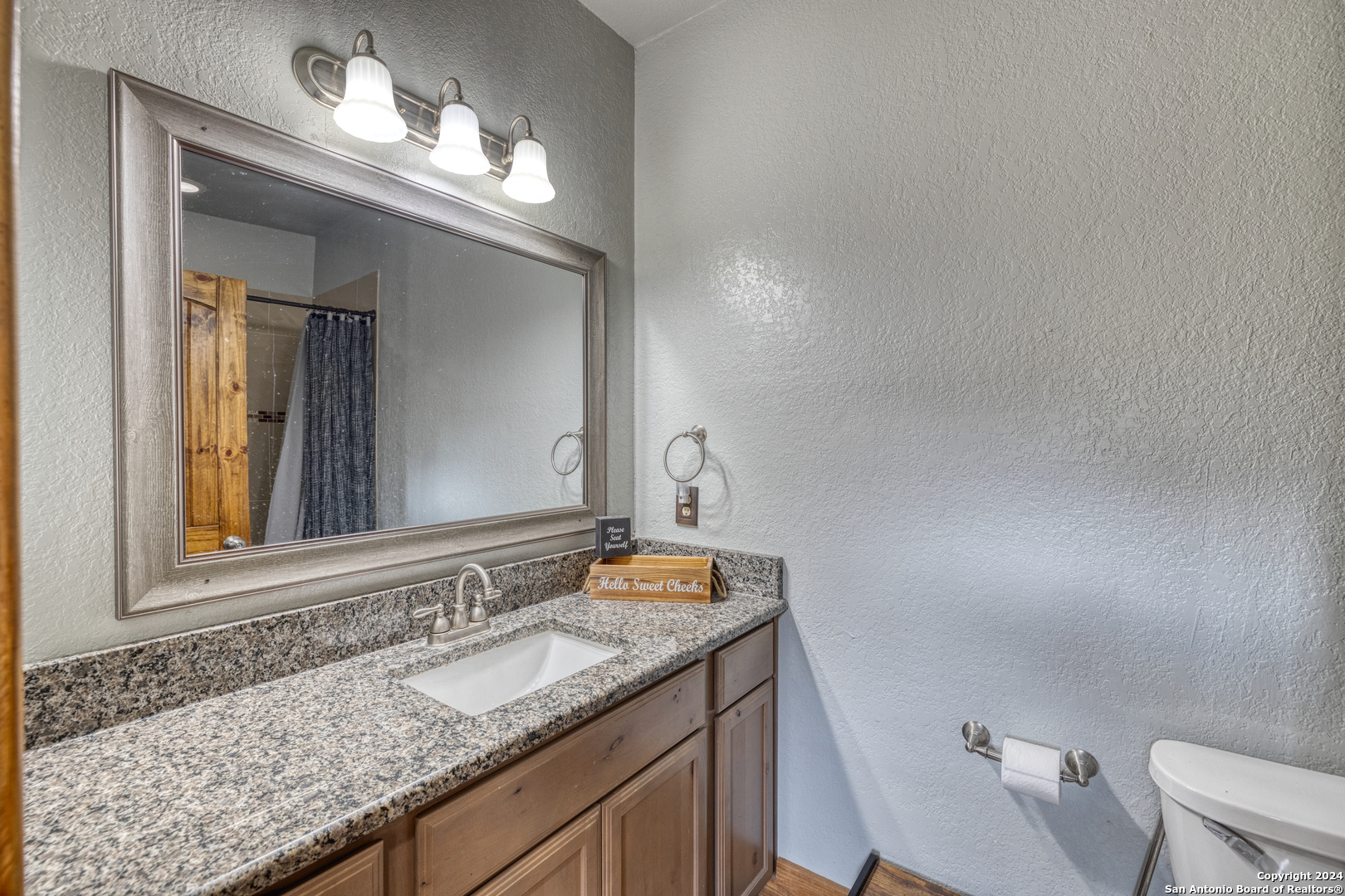 577 Mariposa Concan, TX 78838 - Photo 20 of 39 a bathroom with a granite countertop sink and a mirror