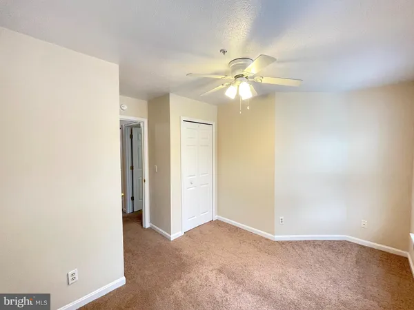 an empty room with a ceiling fan and a bathroom