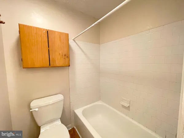 a white toilet sitting next to a white bath tub