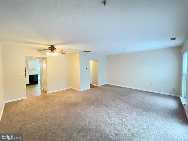 a view of a big room with windows and chandelier fan