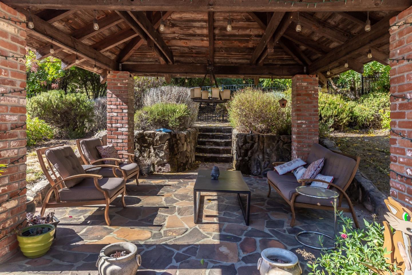 25255 Apple Hill Road Los Gatos, CA 95033 - Photo 29 of 47 a view of a patio with table and chairs and potted plants
