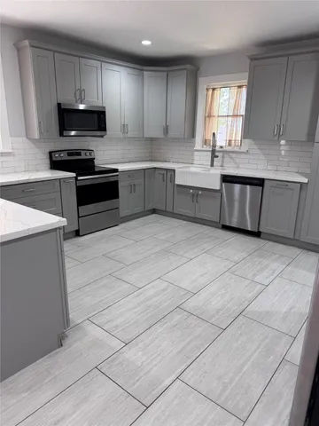 a kitchen with stainless steel appliances granite countertop a stove a sink and a microwave