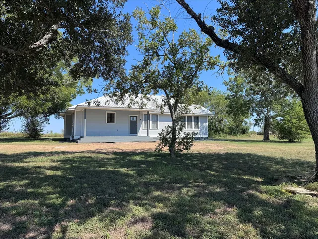 a front view of house with yard and trees