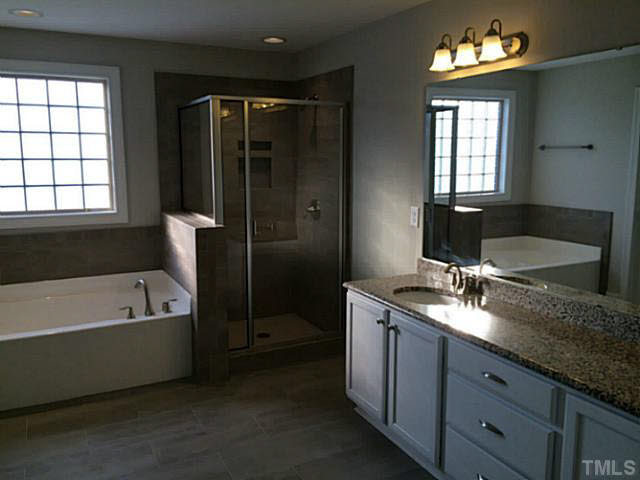 7517 Channery Way, Unit LT34 Raleigh, NC 27616 - Photo 18 of 25 a spacious bathroom with a granite countertop tub sink and mirror