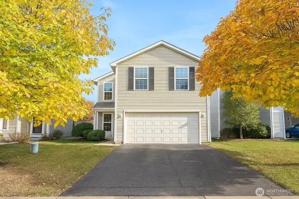 a front view of a house with a yard and garage