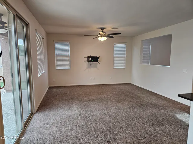 a view of a big room with windows and chandelier fan