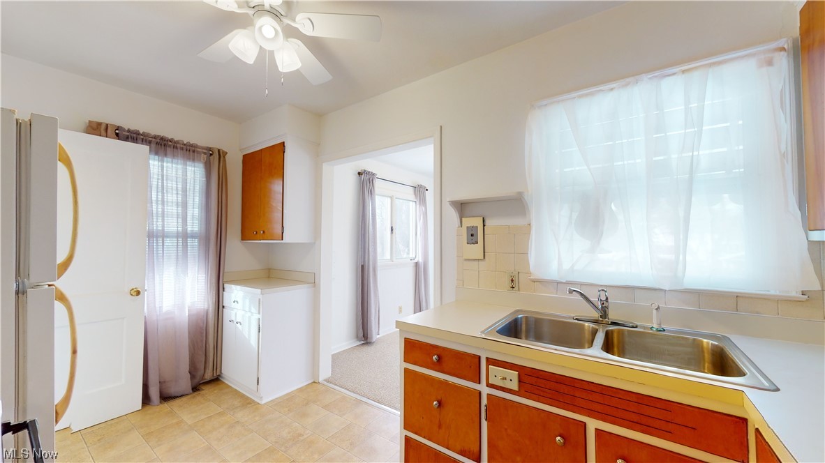 804 Kickapoo Avenue Akron, OH 44305 - Photo 5 of 24 Kitchen 2023 was updated with new paint, ceiling fan, sink facet, blinds, window treatments, and kitchen cabinets were refurnished with fresh paint and brand new kitchen fixtures.