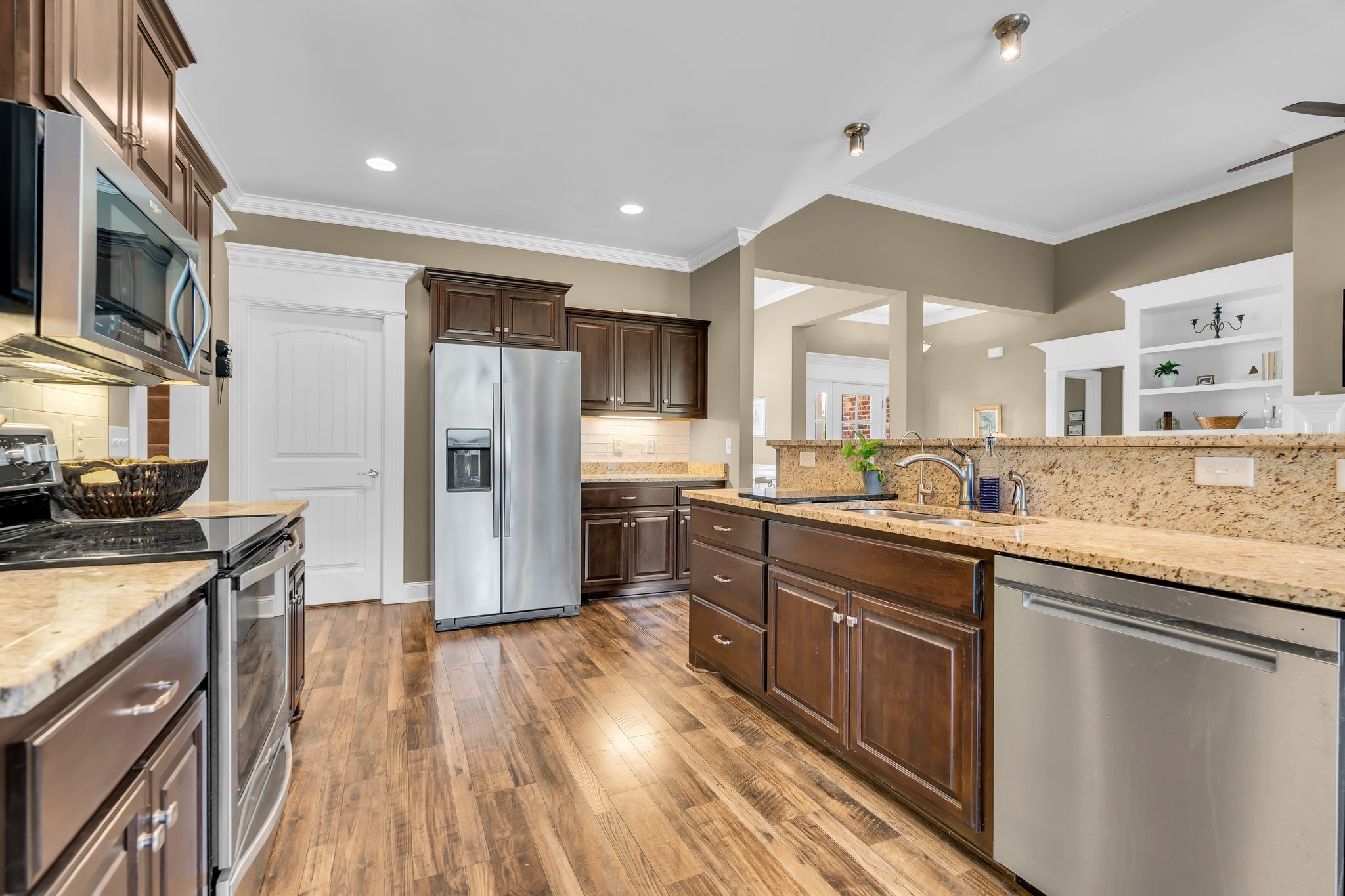 1103 Millstone Creek Road Lascassas, TN 37085 - Photo 11 of 38 a kitchen with stainless steel appliances granite countertop a refrigerator a sink dishwasher a stove and white countertops with wooden floor