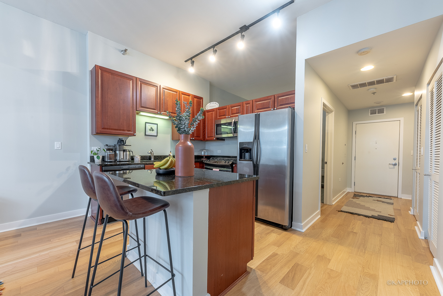 901 West Madison Street, Unit 512 Chicago, IL 60607 - Photo 15 of 36 a kitchen with stainless steel appliances granite countertop a table chairs in it and wooden floors