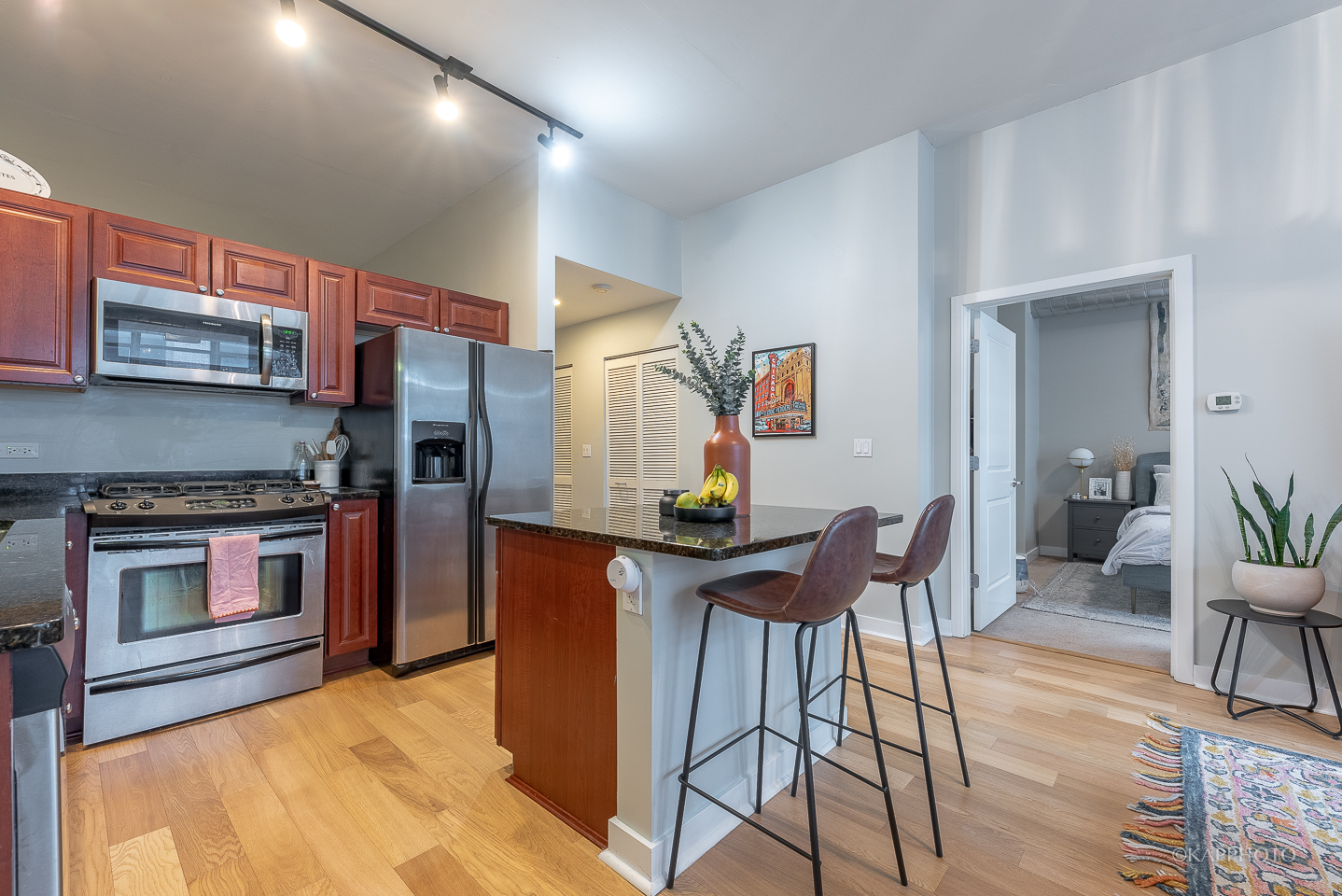 901 West Madison Street, Unit 512 Chicago, IL 60607 - Photo 16 of 36 a kitchen with stainless steel appliances kitchen island granite countertop a table chairs in it and wooden floors