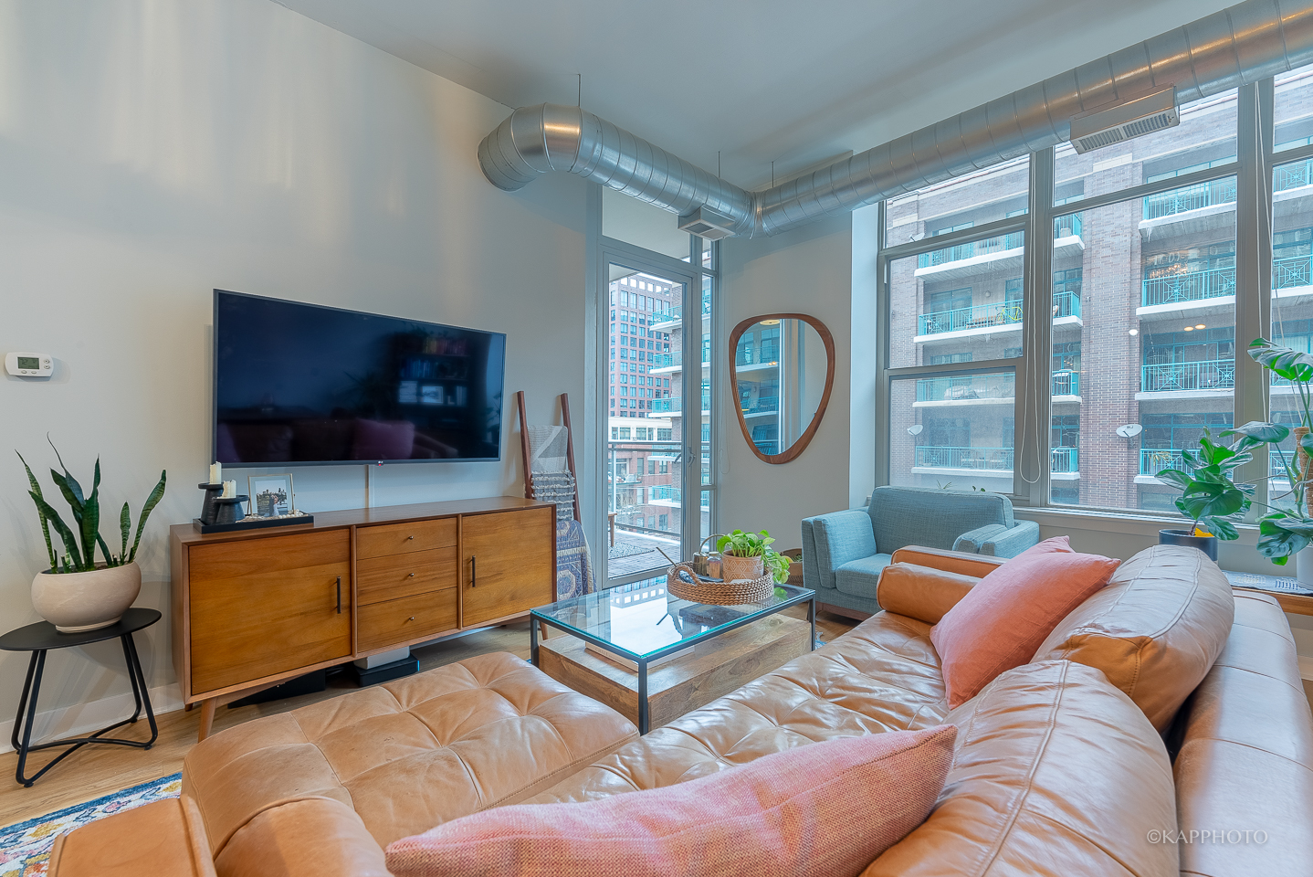 901 West Madison Street, Unit 512 Chicago, IL 60607 - Photo 7 of 36 a living room with furniture a flat screen tv and a floor to ceiling window
