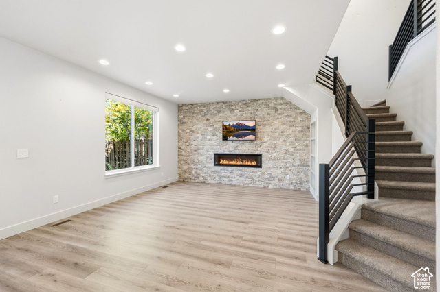 1067 Station Loop Road Park City, UT 84098 - Photo 14 of 38 Expansive living area featuring wood-finish flooring, a stone-clad accent wall with a built-in linear fireplace, and recessed lighting