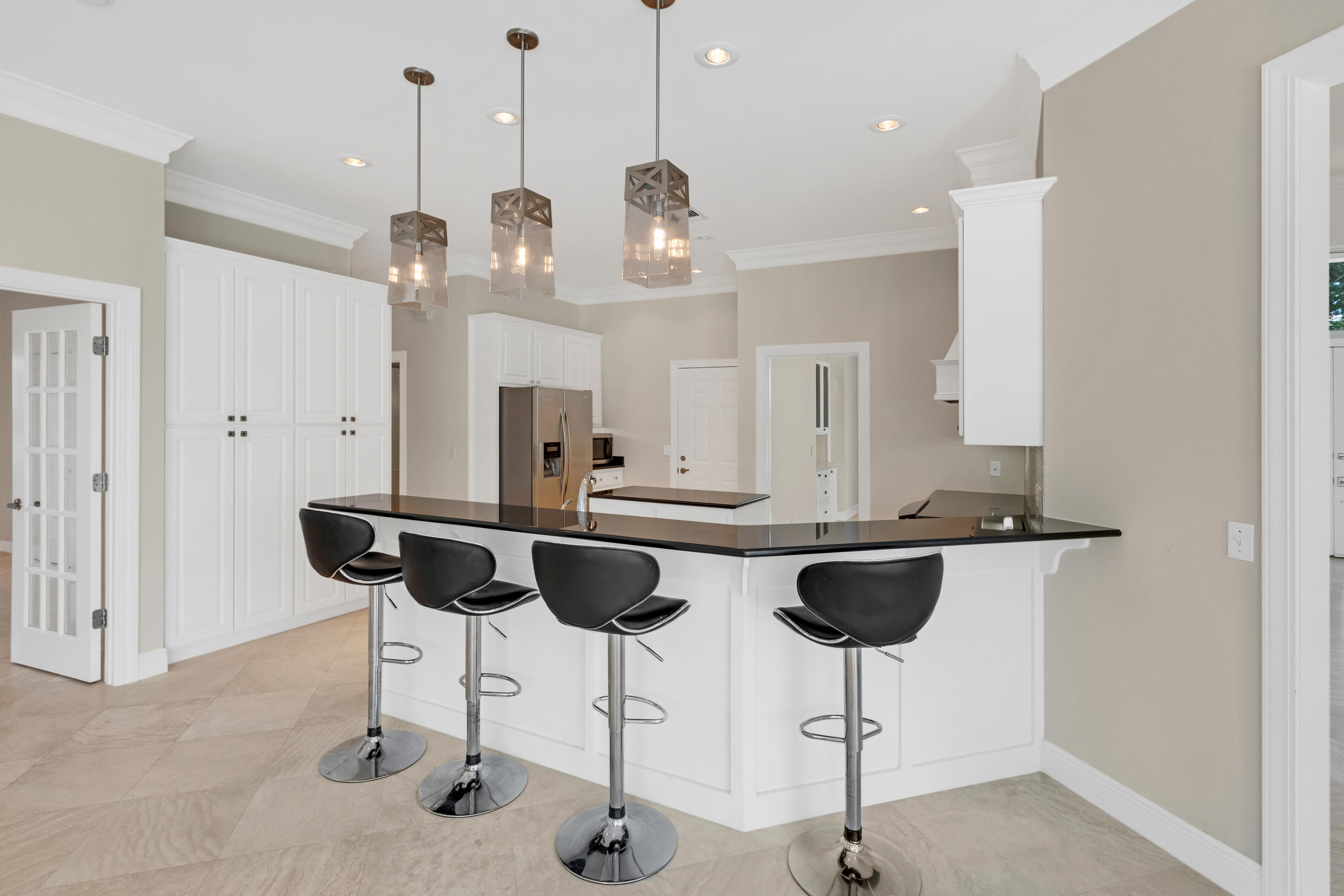 3606 Dragon's Ridge Road Panama City Beach, FL 32408 - Photo 11 of 49 a kitchen with stainless steel appliances kitchen island granite countertop a table and chairs in it