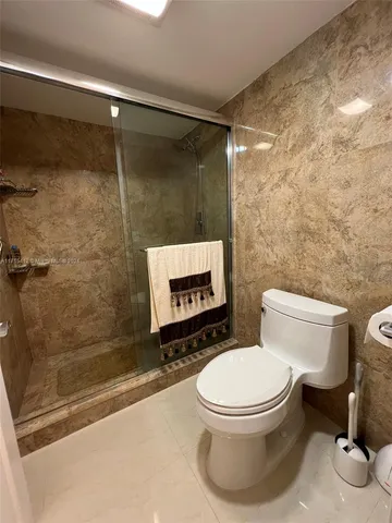 a white toilet sitting next to a bath tub and a shower