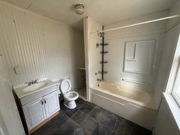 a bathroom with a bathtub toilet and a shower