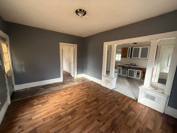 a bedroom with wooden floors and furniture