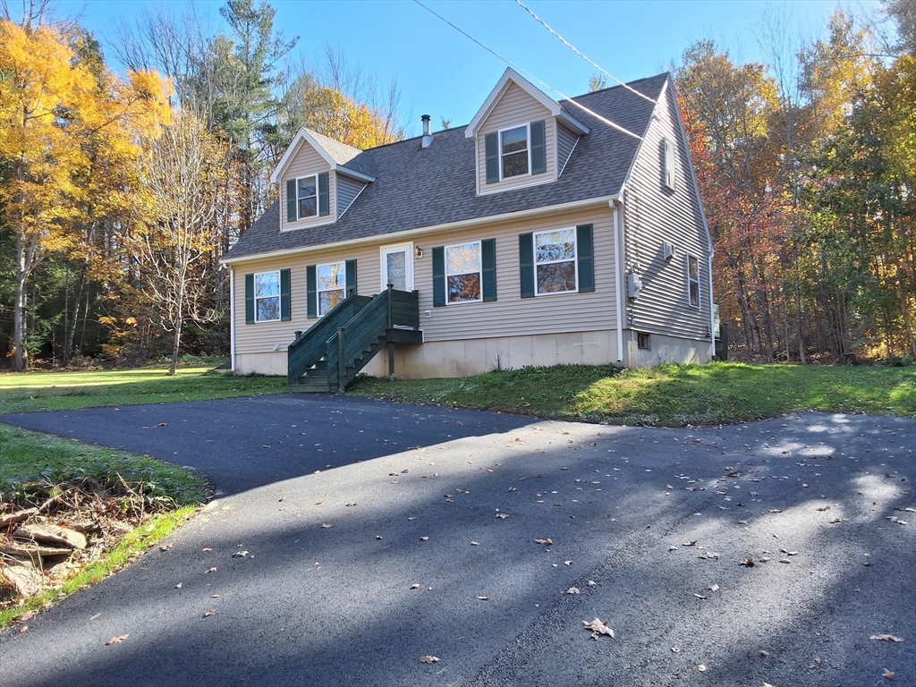 103 Barre Road Oakham, MA 01068 - Photo 2 of 26 a front view of a house with a yard and garage