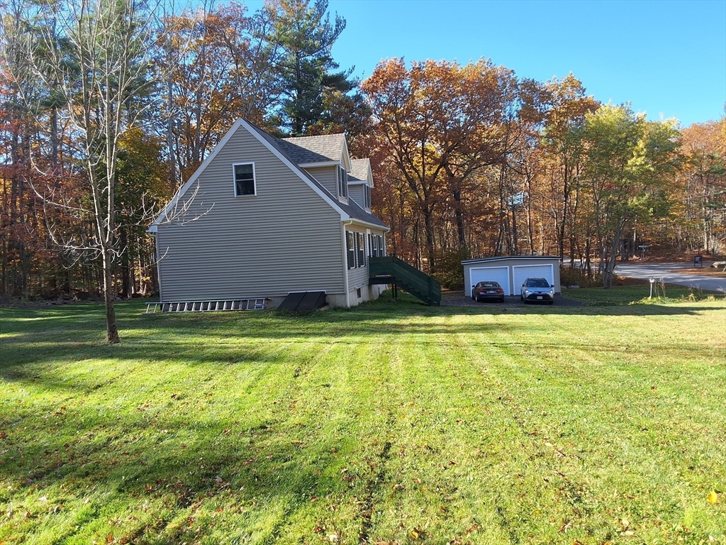 103 Barre Road Oakham, MA 01068 - Photo 4 of 26 a front view of house with yard and trees in the background