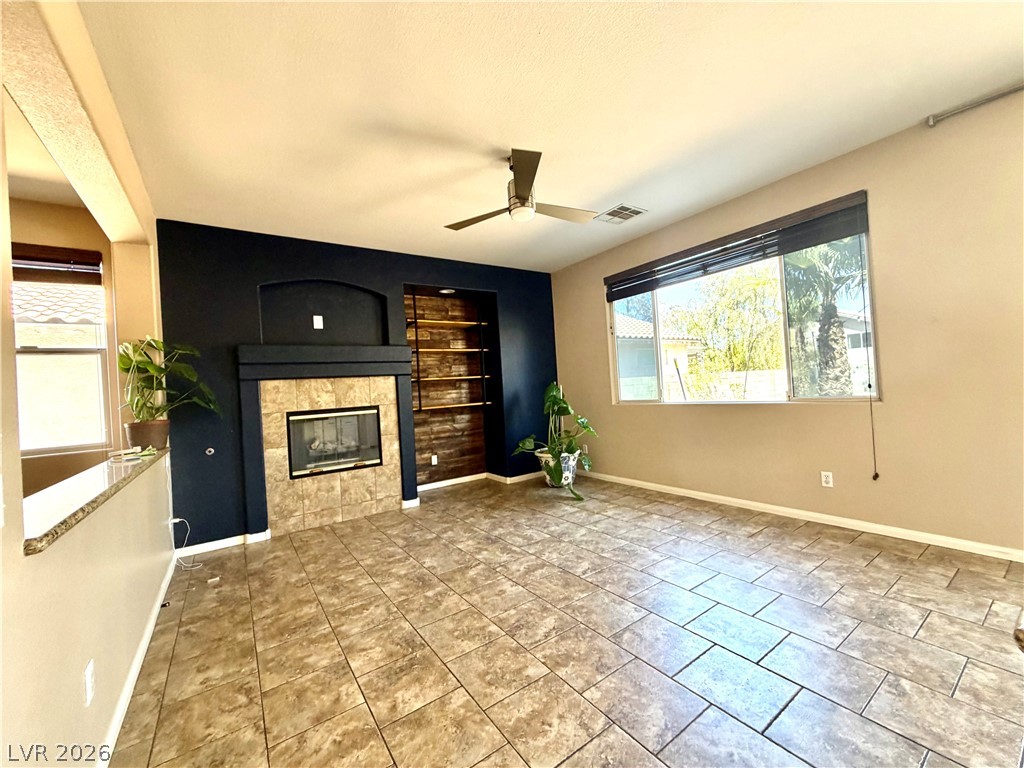 3936 Gold Point Street Las Vegas, NV 89129 - Photo 5 of 23 A welcoming living room featuring a cozy fireplace and built-in shelving, perfect for relaxation.
