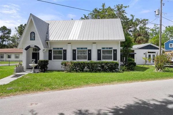 a front view of a house with a garden and plants